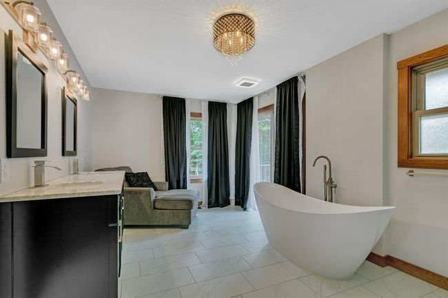 Spa like primary bathroom with patio doors leading to the backyard | Image 18