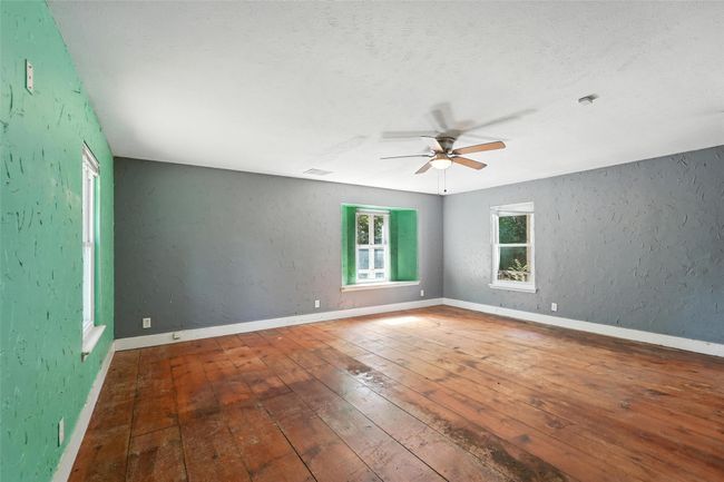Empty room featuring hardwood / wood-style flooring, a ceiling fan, and a textured wall | Image 23