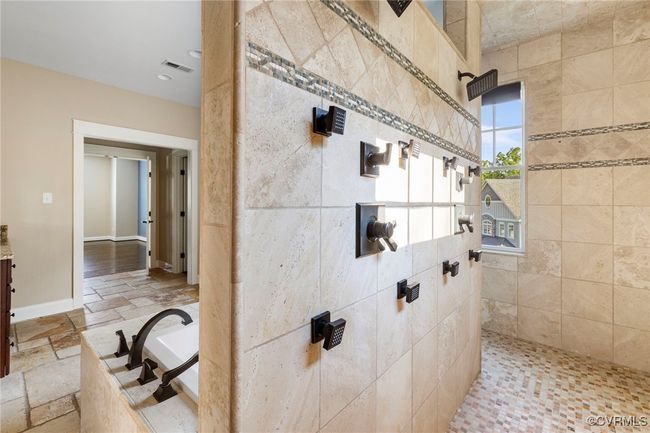 Bathroom with tiled shower, a bath, stone tile floors, vanity, and recessed lighting | Image 33