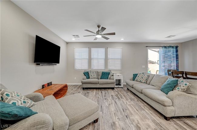 Living room with light wood-style floors, ceiling fan, baseboards, and recessed lighting | Image 11