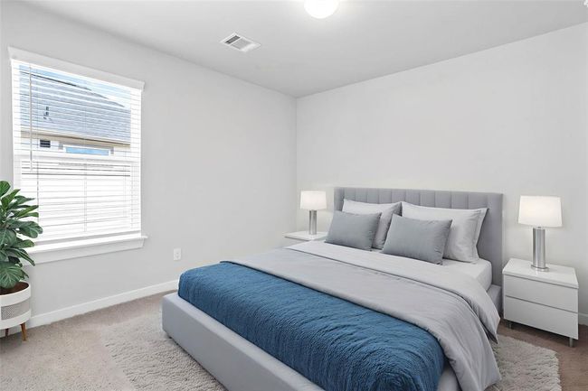 Secondary bedroom features plush carpet, custom paint, lighting, closet space, and a window with privacy blinds. | Image 16