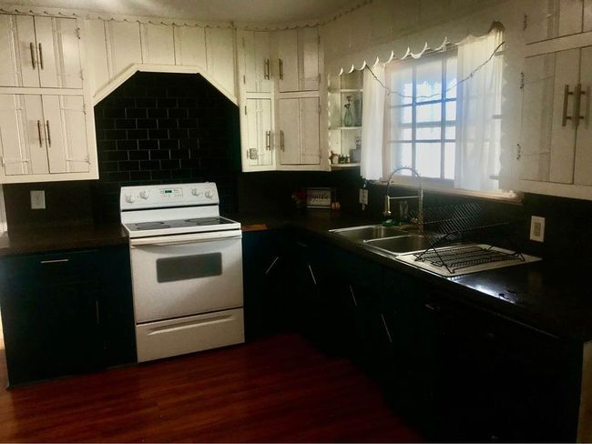 Kitchen featuring a sink, dark wood-style flooring, white cabinetry, and electric range | Image 5