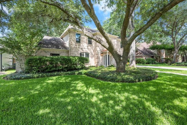 An impressive, gorgeously trimmed oak tree towers majestically over the front lawn, adding timeless beauty and shade to the property. | Image 39