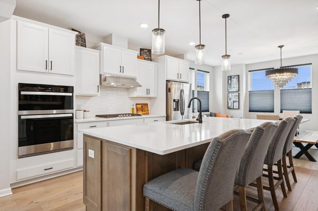 Chef’s kitchen featuring a gas stove and a central island, designed for both cooking and gathering. | Image 19