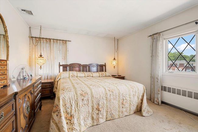 Bedroom featuring radiator heating unit and carpet flooring | Image 13