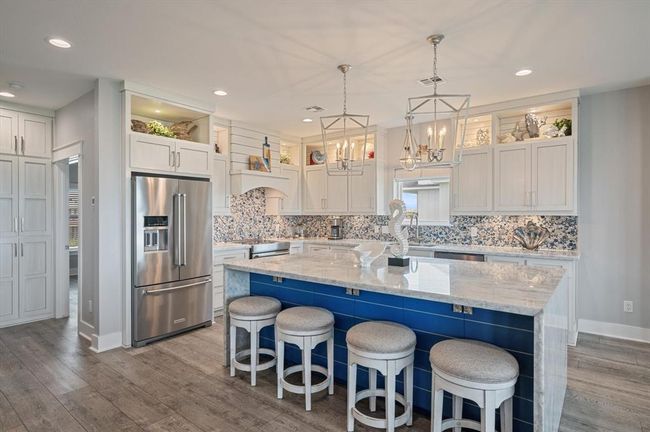 This gorgeous kitchen has ample storage under the island. | Image 19