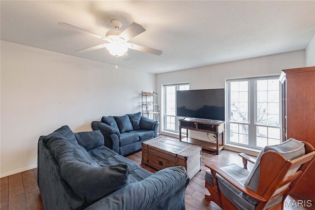 Living area featuring dark wood-style floors and ceiling fan | Image 7