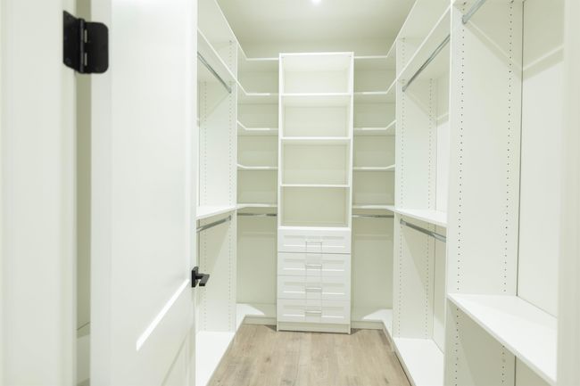 Walk in closet with light wood finished floors | Image 15