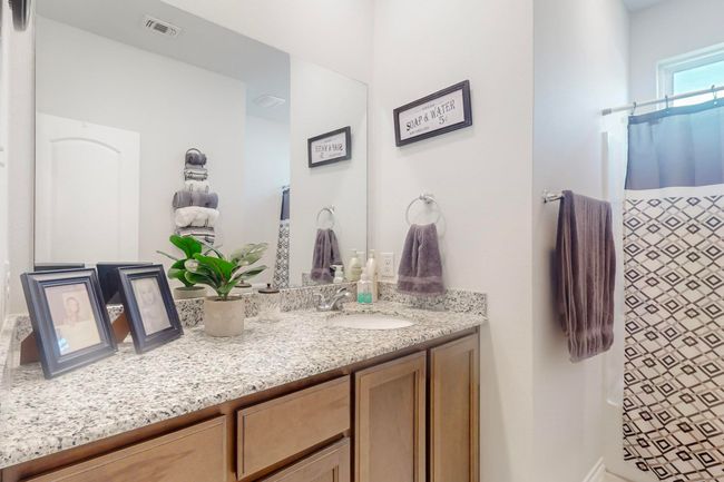 Bathroom featuring visible vents, curtained shower, and vanity | Image 11