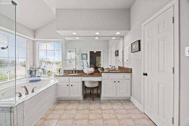 In suite primary bathroom with seamless shower, jacuzzi tub and privacy toilet area with dual sinks. | Image 22