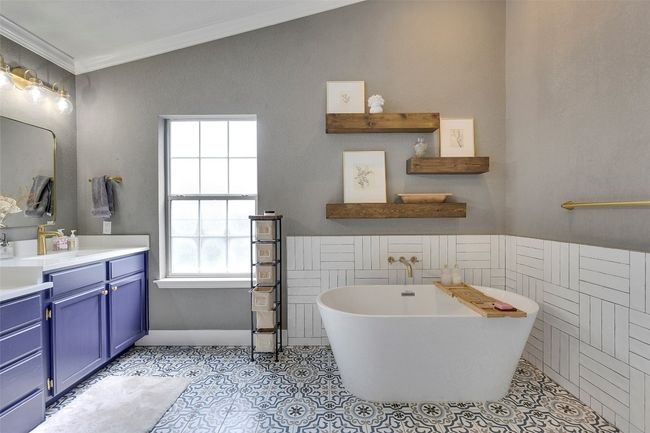 Bathroom with plenty of natural light, vanity, a freestanding tub, ornamental molding, and tile patterned flooring | Image 24