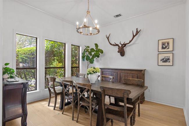 Dining room with light wood-style flooring, baseboards, visible vents, a chandelier, and ornamental molding | Image 21