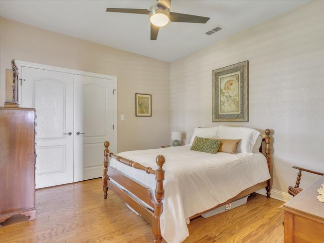 Bedroom with light wood-type flooring, baseboards, and ceiling fan | Image 24