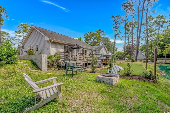 Rear view of house with a deck, a yard, and roof with shingles | Image 29