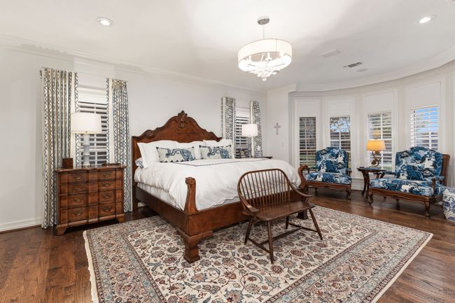 Large downstairs primary bedroom with beautiful hardwoods and plantation shutters | Image 17