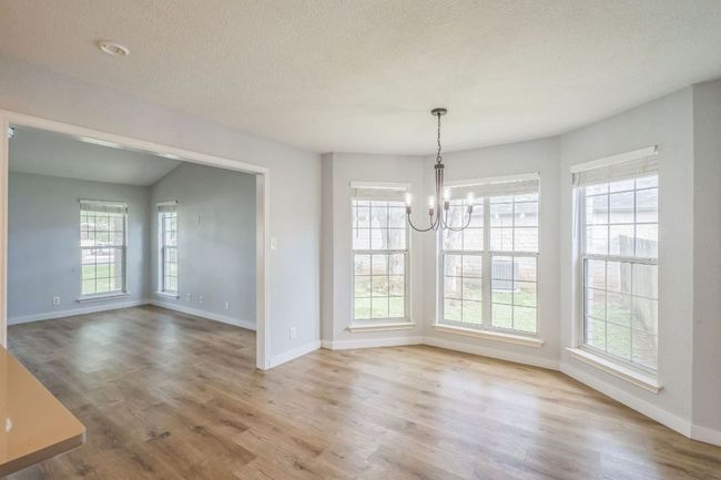 Dining area with a chandelier, wood finished floors, and a textured ceiling | Image 12