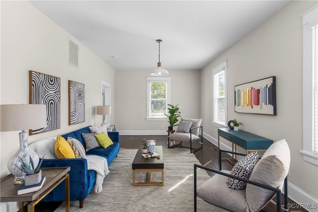 Living area featuring wood finished floors, visible vents, and baseboards | Image 9