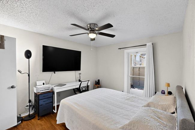 Bedroom featuring wood finished floors, ceiling fan, and a textured ceiling | Image 11