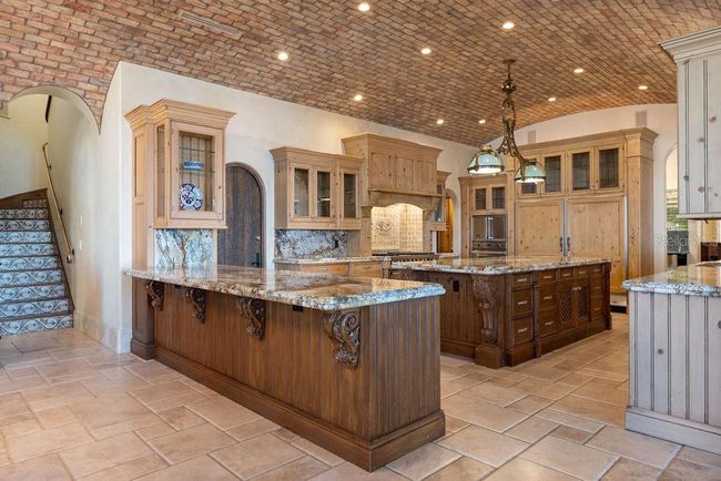 Kitchen w/ redbrick barrel ceiling. Stairs are the second entry to the game lounge and upstairs areas. | Image 25