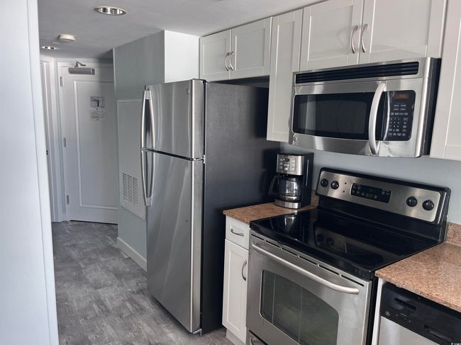 Kitchen featuring appliances with stainless steel finishes, white cabinetry, and light wood-style flooring | Image 10