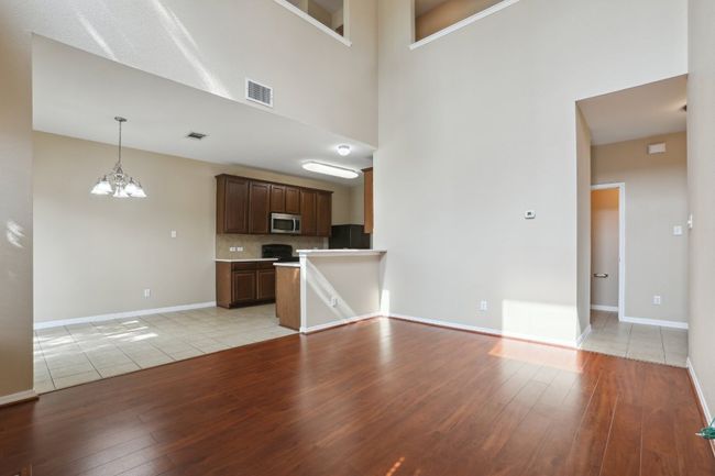 Unfurnished living room featuring baseboards, visible vents, and light wood-style floors | Image 9