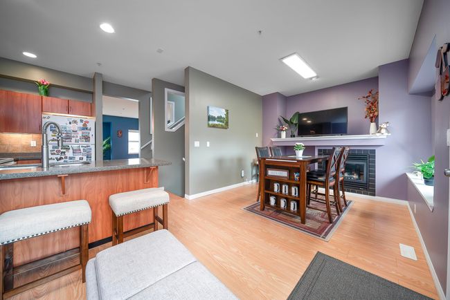 Dining space featuring baseboards, a tile fireplace, and light wood finished floors | Image 14