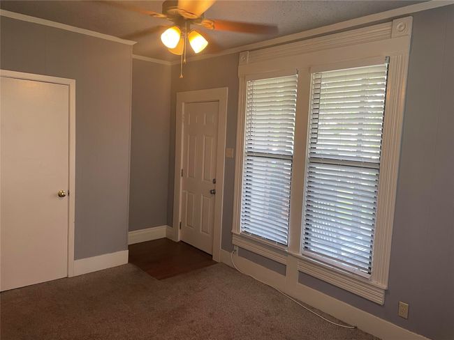 Carpeted entryway featuring a ceiling fan and ornamental molding | Image 7