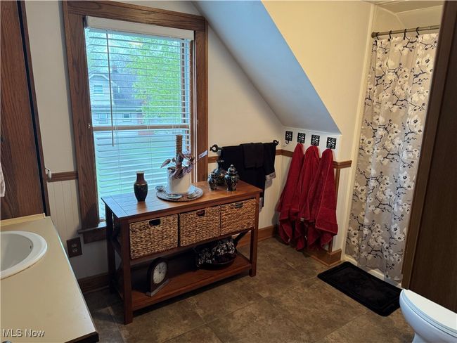 Full bath featuring lofted ceiling, toilet, curtained shower, and vanity | Image 15