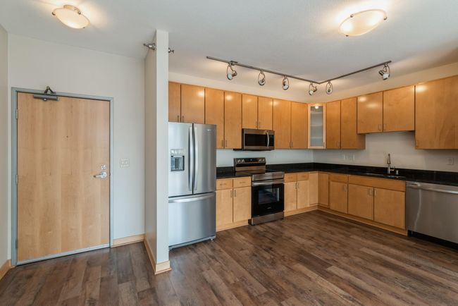 This unit has a wonderful open kitchen with maple cabinets, SS appliances and granite counters. (The photos are of unit 401. Owned by the same person and finishes that are VERY similar) | Image 24