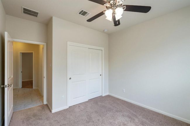 Another view of secondary bedroom #1 with ceiling fan and closet. | Image 28