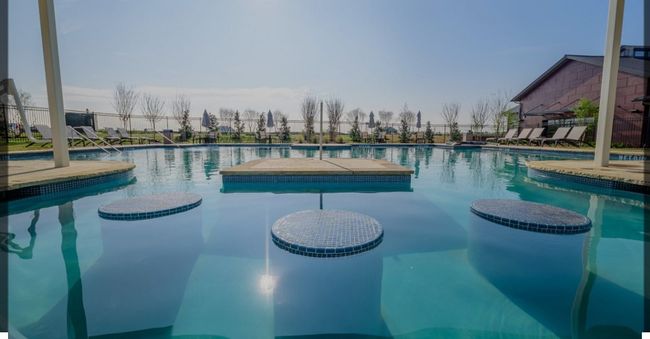 Pool featuring a patio area, a water play area, a water slide, and fence | Image 35