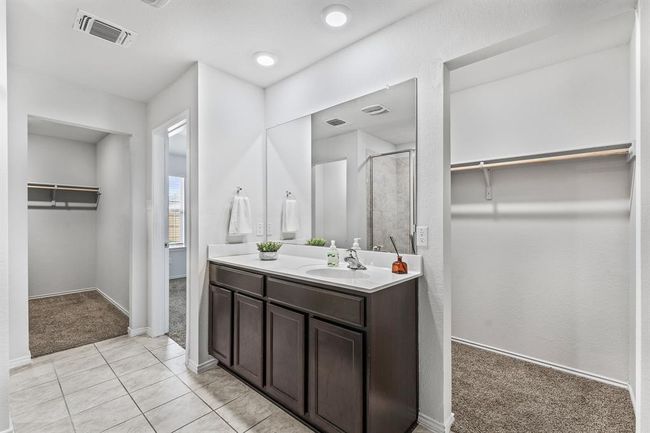 Full bath featuring a spacious closet, vanity, a stall shower, and tile patterned flooring | Image 9