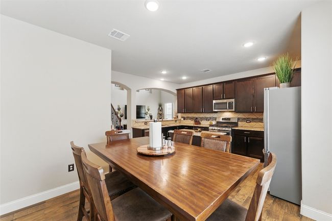 Dining room featuring visible vents, baseboards, arched walkways, recessed lighting, and wood finished floors | Image 15