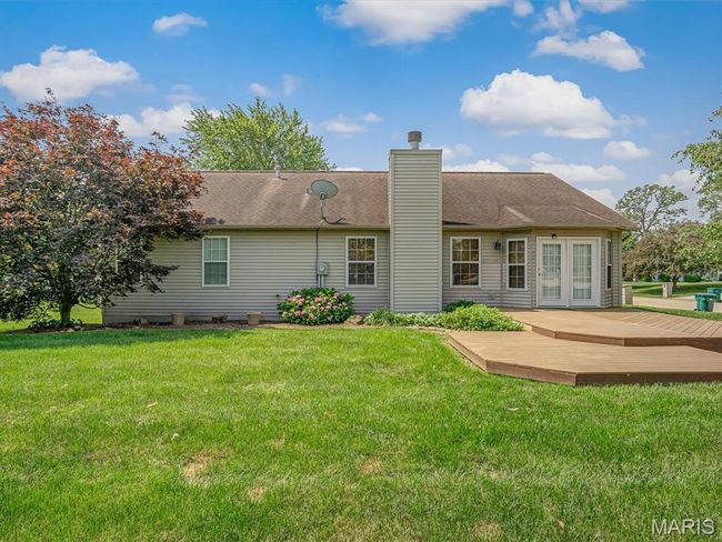 Rear view of property with a wooden deck, a chimney, a lawn. | Image 31