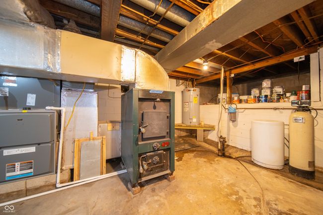 unfinished below grade area featuring water heater, a water softener system, and heating unit | Image 29