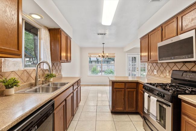 The open design of the kitchen effortlessly flows into the dining area, creating a perfect space for both everyday meals and hosting guests | Image 10
