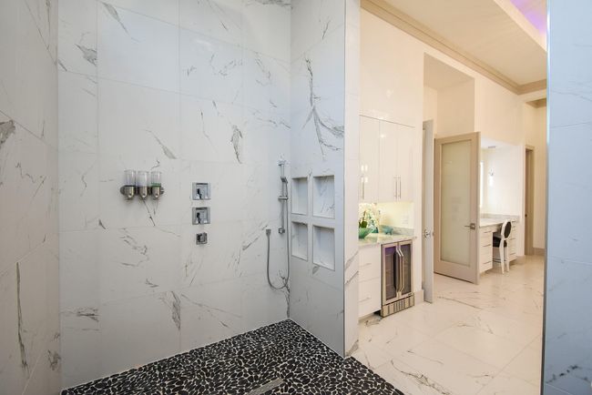 Massive walk-in shower features multiple shower heads, including rain shower heads, and stylish nooks for storing away your items. | Image 28