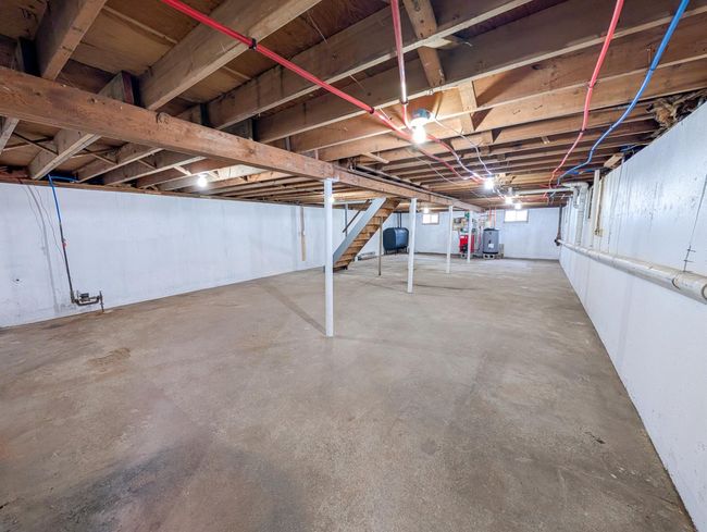Unfinished basement with stairs and water heater | Image 24