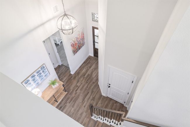 Stairs with a towering ceiling, an inviting chandelier, and wood finished floors | Image 25