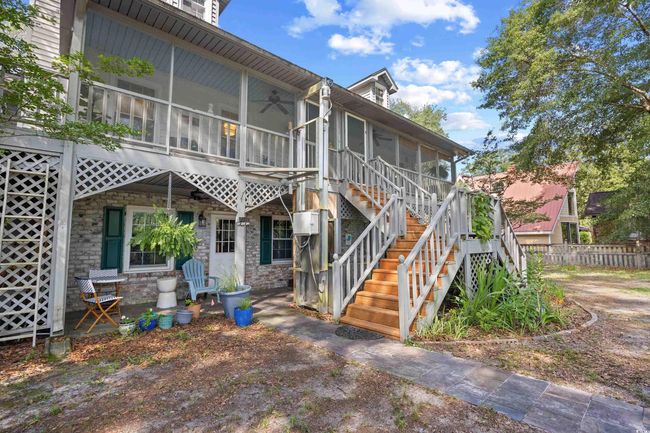 Back of property with a sunroom, stairs, stone siding, and ceiling fan | Image 31