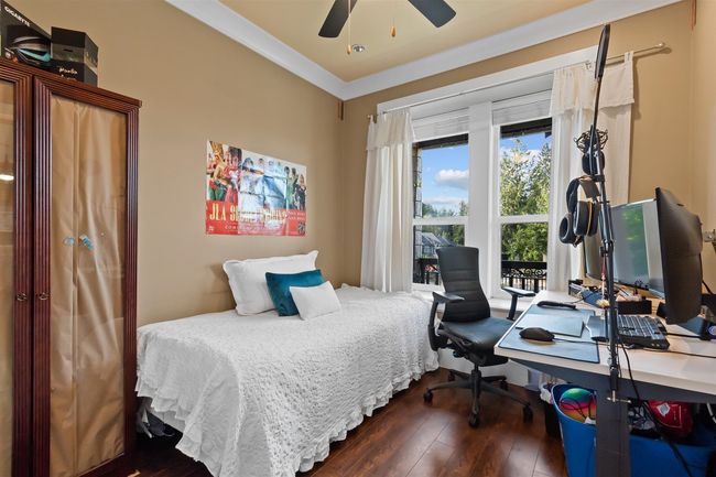 Bedroom featuring dark wood finished floors, an office area, and ceiling fan | Image 25