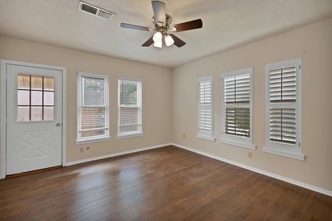 Front bedroom with a textured ceiling, a ceiling fan, hardwood flooring and two closets | Image 23