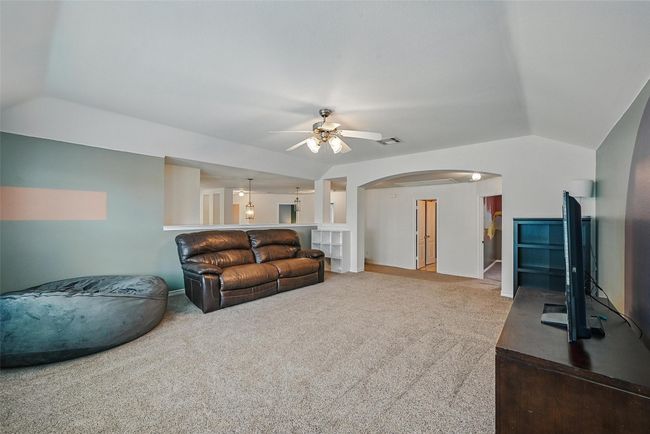 Living area featuring arched walkways, vaulted ceiling, a ceiling fan, and carpet floors | Image 28