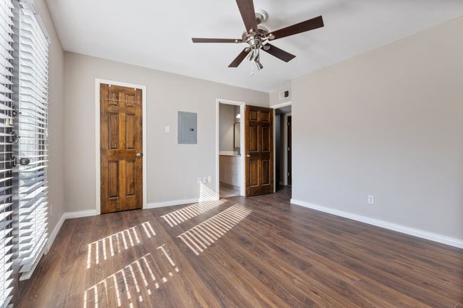 Unfurnished bedroom with electric panel, visible vents, multiple windows, and baseboards | Image 15