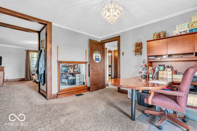 carpeted home office with a chandelier and ornamental molding | Image 34