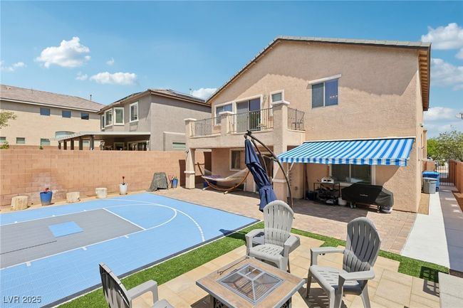 View of basketball court with a fenced backyard and basketball hoop | Image 62