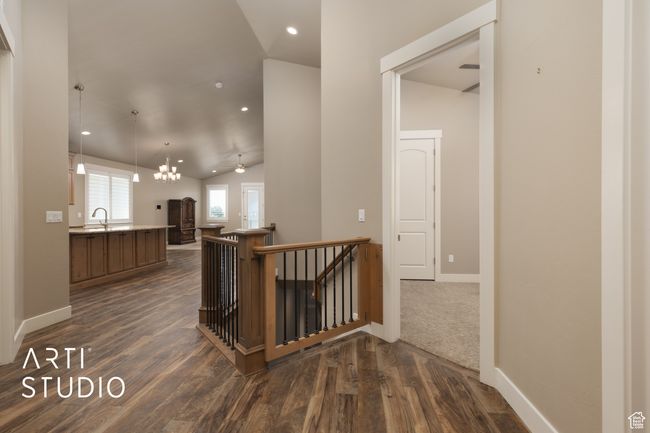 Hall featuring an upstairs landing, lofted ceiling, dark wood-style floors, and recessed lighting | Image 9