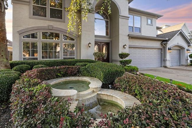 At the front of the home is this beautiful fountain surrounded by lush landscaping that greets your guests. | Image 4