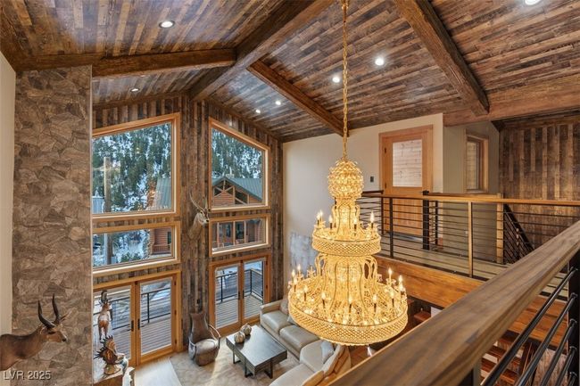 Sitting room with a chandelier, wooden ceiling, and vaulted ceiling with beams | Image 16