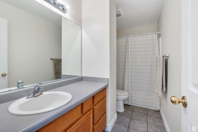 Full bath featuring tile patterned flooring, vanity, and curtained shower | Image 7